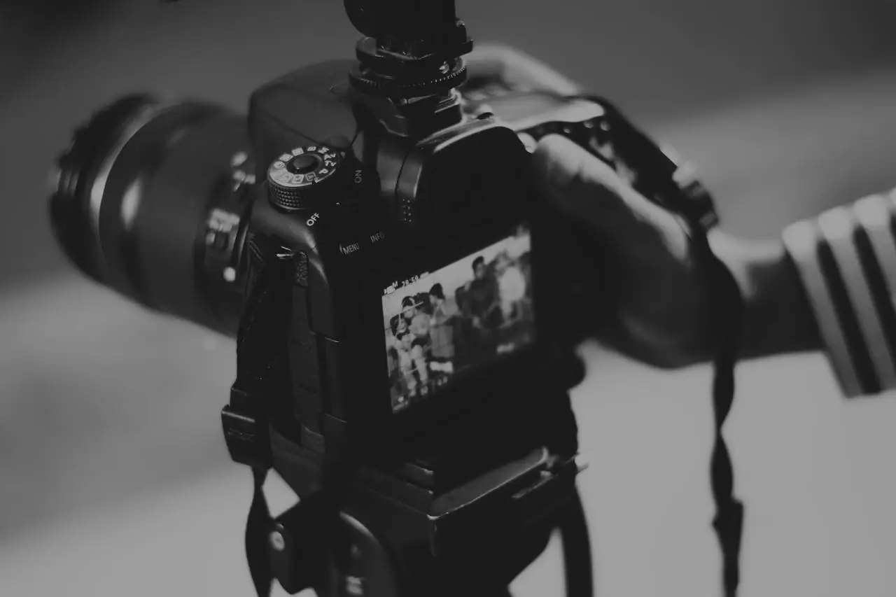 Black and white image of a DSLR camera capturing people in focus, showcasing photography professionalism.